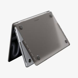 Spigen MacBook Pro 14-inch Air Skin in Frost Black showing the bottom exterior with four rubber feet and the Spigen logo visible on a white background
