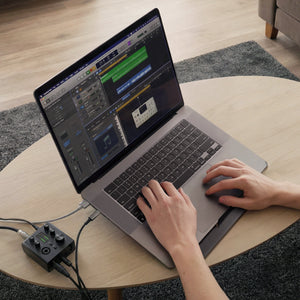AMP11117 - Slim Fold Laptop Stand | Non-Adhesive | Black LD201-S8 showing person's hands typing on MacBook laptop propped up on the laptop stand