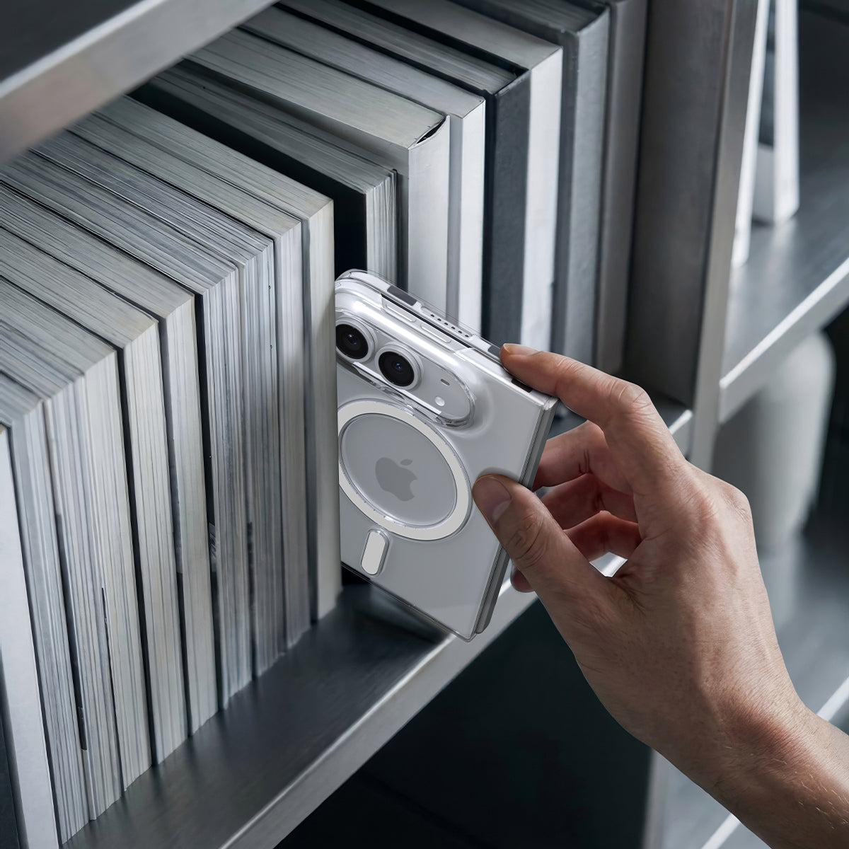 Spigen Air Skin MagFit Clear White case for iPhone Duo – folded phone held beside a row of books