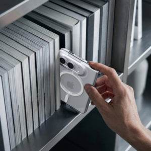 Spigen Air Skin MagFit Clear White case for iPhone Duo – folded phone held beside a row of books