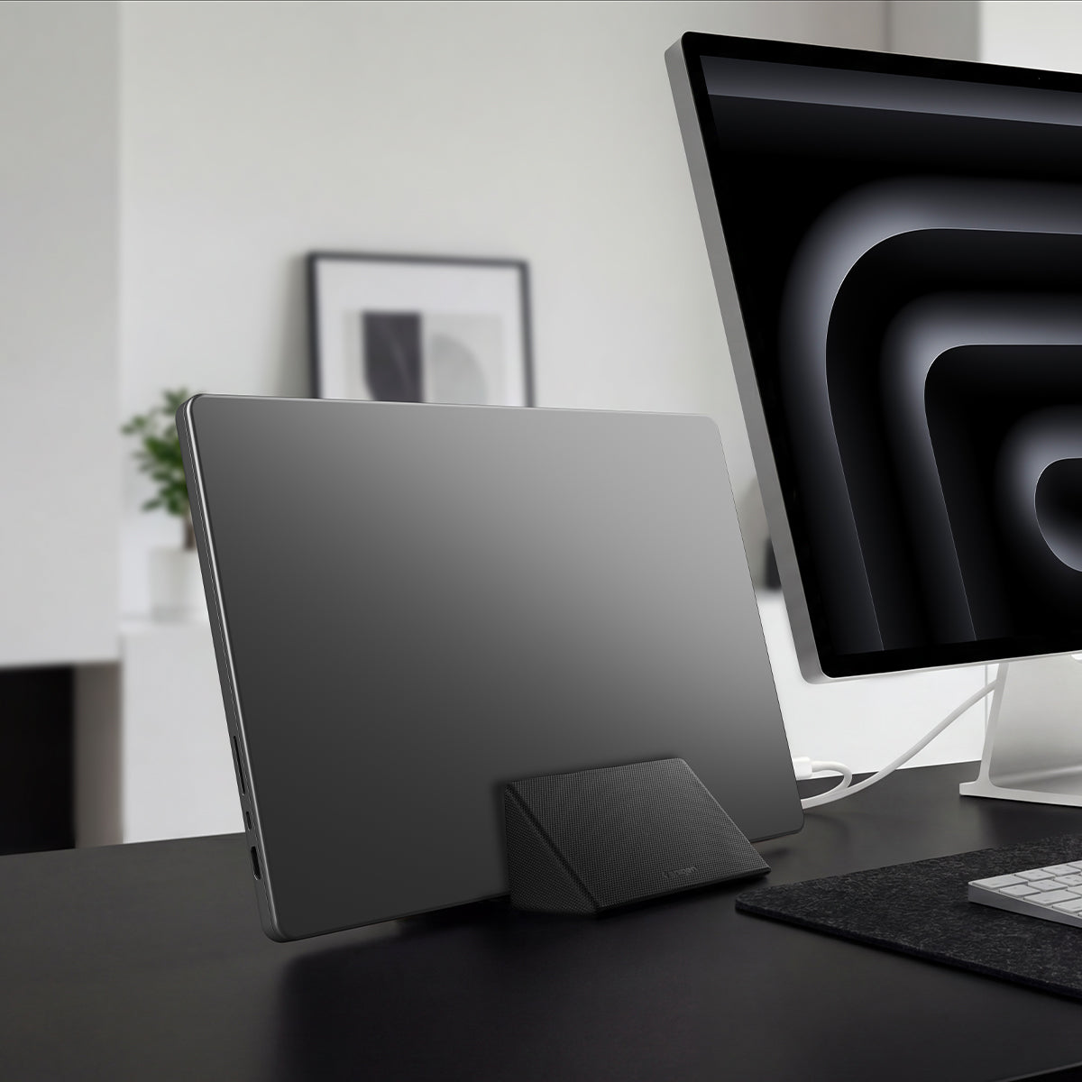 AMP11118 - Slim Fold Laptop Stand | Non-Adhesive | Black LD201-S9 showing MacBook laptop vertically mount to the laptop stand for storage