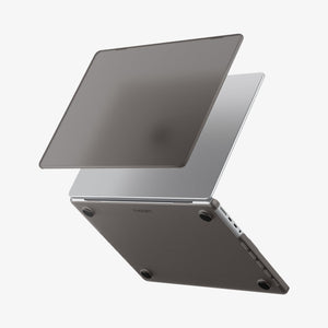 Spigen MacBook Pro 14-inch Air Skin in Frost Black showing the top shell of the Frost Black case lifting away from the MacBook to illustrate the two-piece snap-on design